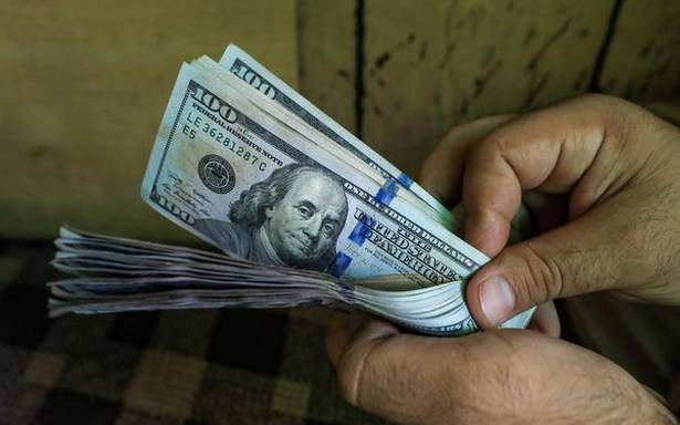 FILE PHOTO A trader counts US dollar banknotes at a currency exchange booth i