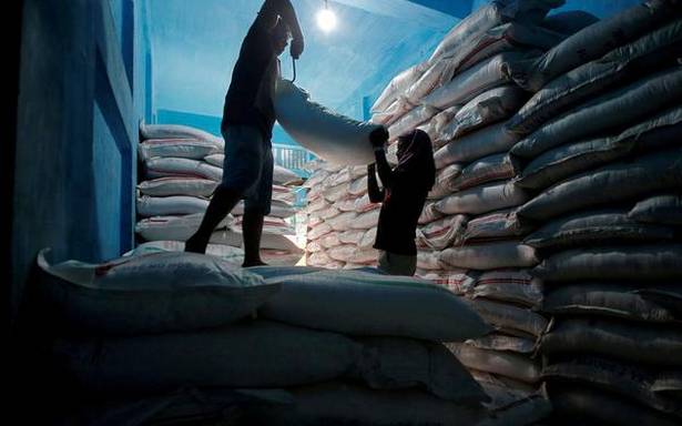 FILE PHOTO Labourers lift a sack filled with sugar to load it onto a handcart a