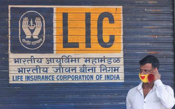 Man speaks on his phone outside the Life Insurance Corporation of India LIC of